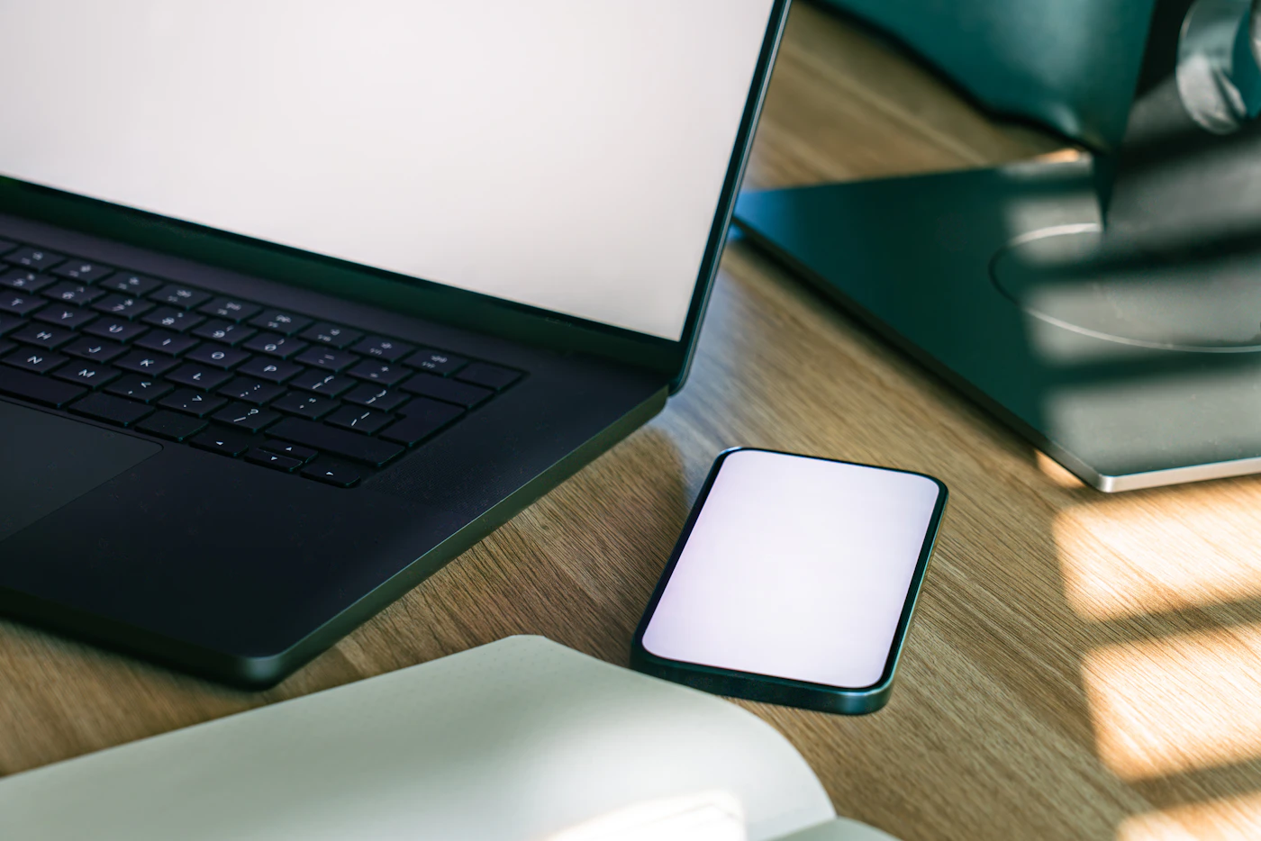 Computador portátil e telemóvel numa mesa de trabalho
